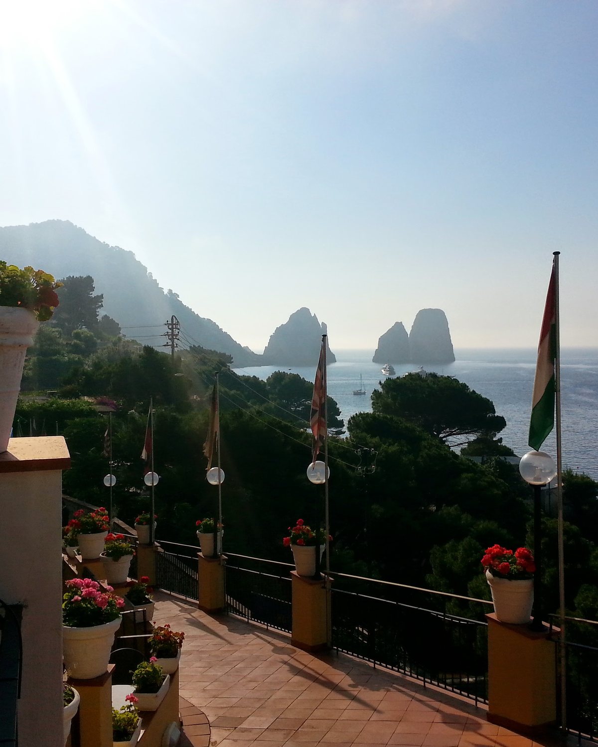 A flowered terrace looking out toward the Faraglioni of Capri
